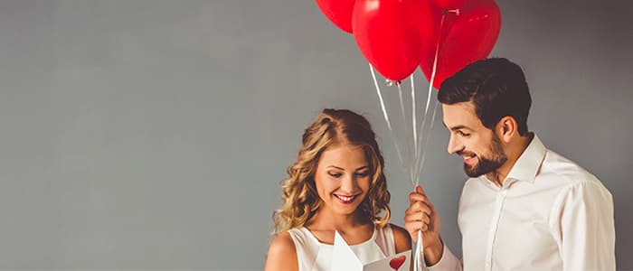 Un homme et une femme amoureux qui tiennent des ballons