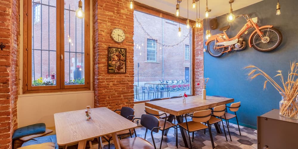 Campagne restaurent Toulouse, mur en brique, ambiance chaleureuse, lumière, grandes fenêtres